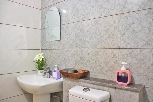 a bathroom with a white toilet and a sink at Gypsy Soul Gateaway in Zirakpur