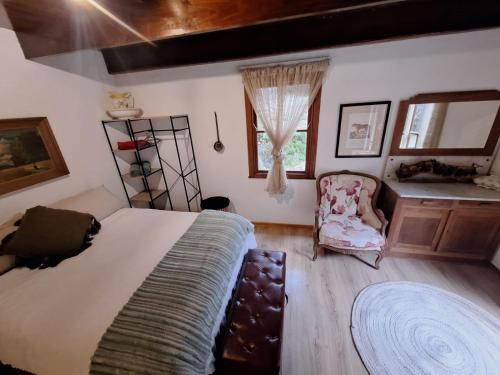 a bedroom with a large bed and a chair at Bubuhle Self Catering Cottage in Hogsback