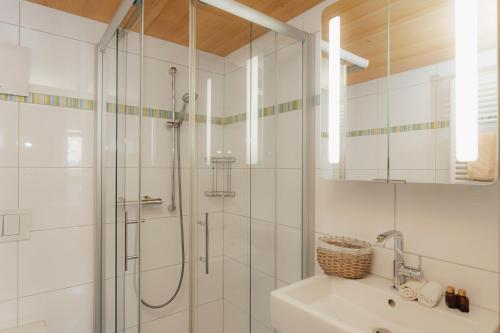a white bathroom with a shower and a sink at Seabreeze Suite in Füssen