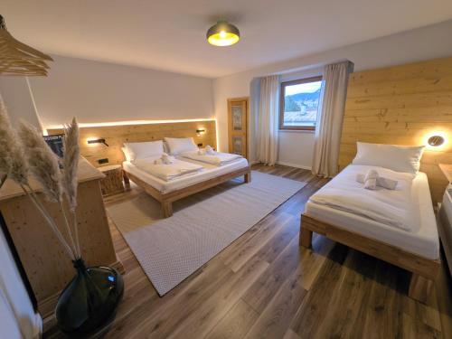 a hotel room with two beds and a window at Chic Alpine Oasis in Oberammergau with Mountain View in Oberammergau