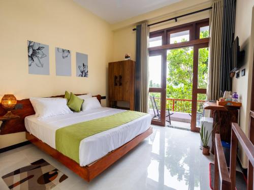 a bedroom with a bed and a large window at Mashmellow Resort and Spa in Galle