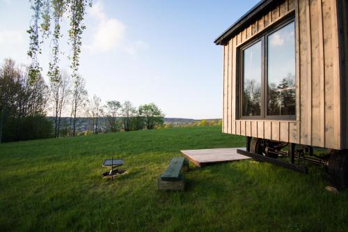 a tiny house sitting on top of a lush green field at Maringotka pod Smrkem in Nové Město pod Smrkem