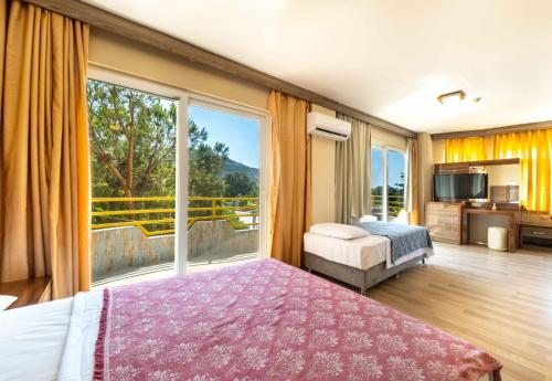 a bedroom with a bed and a large window at Selinus Beach Club Hotel in Gazipasa