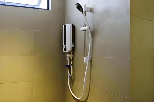 a shower in a bathroom with a phone on the wall at Roxy Beach Apartment, Sematan, Sarawak in Sematan