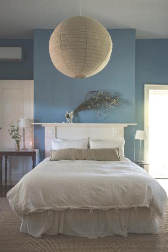 a bedroom with a large bed and a large light fixture at Way's Cottage in McLaren Vale