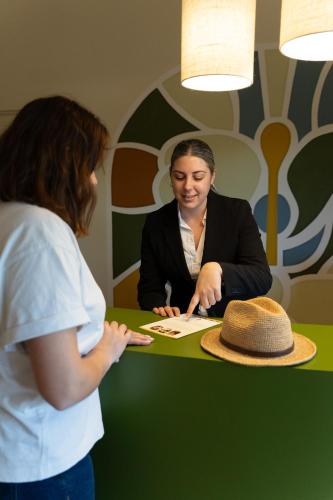 a woman sitting at a table with a hat at Logis Hostellerie De L'Abbaye in Le Thoronet