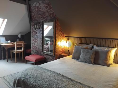 a bedroom with a bed and a desk and a mirror at Laclos des champs in Vadencourt