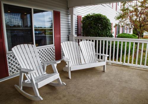 two white rocking chairs sitting on a porch at Country Inn & Suites by Radisson, Gurnee, IL in Gurnee