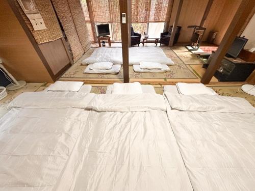a group of white beds in a room at 民泊Toshi29 in Wadomari
