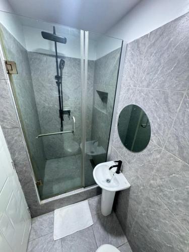 a bathroom with a shower and a toilet and a sink at The Adun Grove in Lekki