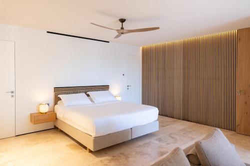a bedroom with a bed and a ceiling fan at Villa On the Rocks in Finikounta