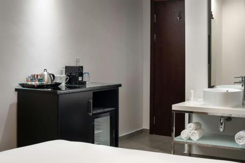 a bathroom with a sink and a counter with a sink at Protea Hotel Fire & Ice by Marriott Cape Town in Cape Town