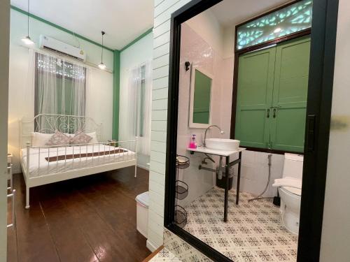 a bathroom with a bed and a sink and a toilet at Green Teak House in Bangkok