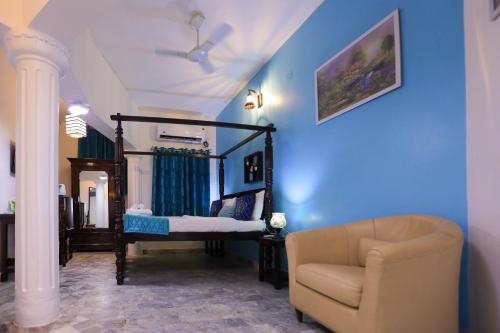 a living room with a chair and blue walls at Le Clarisse Guest House in Pondicherry