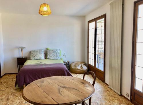 a bedroom with a bed and a wooden table at Le toit d'éco pins in Le Luart