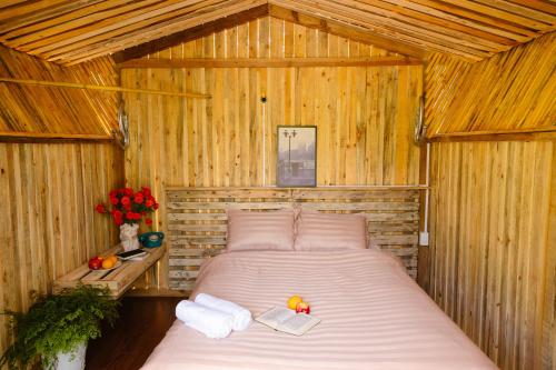 a bedroom with a bed in a wooden room at Làng Hương Village in Teurnoum
