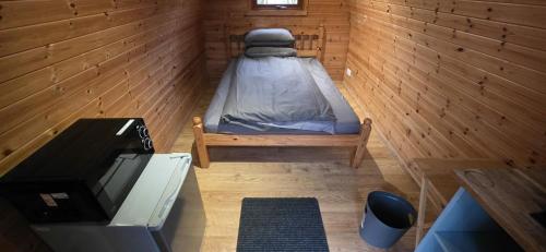 a small room with a small bed in a cabin at Wyreside Lakes Glamping Pods in Lancaster