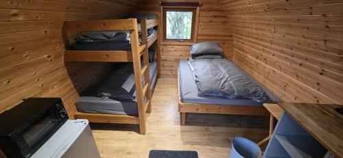 a cabin with two bunk beds and a tv at Wyreside Lakes Glamping Pods in Lancaster