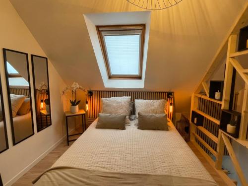 a bedroom with a bed with two pillows and a window at Appartement proche Zenith & Polyclinique in Nantes