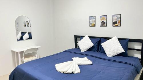 a blue bed with two white pillows on it at SP House Khao Sok in Khao Sok National Park