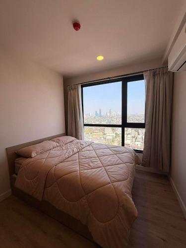a bedroom with a bed and a large window at Xim Condo in Bangkok 20 mins to Asiantique in Ban Tha Hin