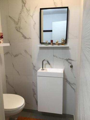 a white bathroom with a sink and a mirror at La casa in Tielt
