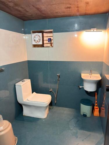 a bathroom with a toilet and a sink at Aravanazhi tharavadu in Thirunelli