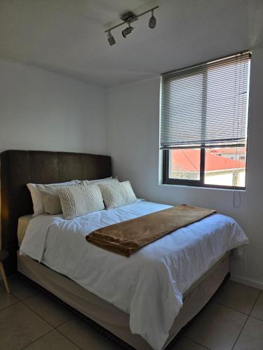a bedroom with a large bed with a window at Prestige stays in Windhoek