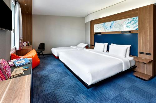 a large white bed in a hotel room at Aloft by Marriott Stuttgart in Stuttgart