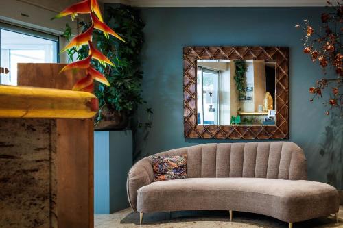 a living room with a couch and a mirror at Hotel 't Paviljoen in Rhenen