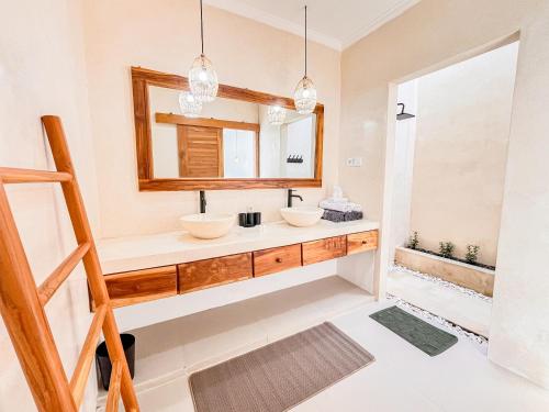 a bathroom with two sinks and a mirror at Dolphin - New luxury rooms in Lovina Centre & near the beach in Lovina