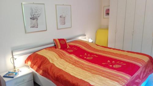 a bedroom with a bed with a colorful blanket on it at Wasgau Urlaubserlebnis Fels und Seen in Ludwigswinkel