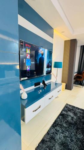 a living room with a tv and a large screen at Elevenstay in Ghaziabad