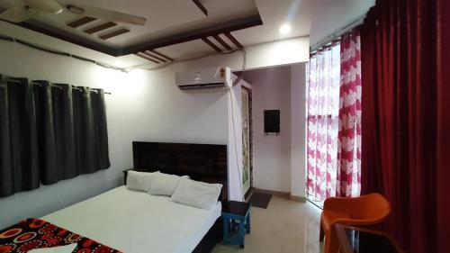 a bedroom with a bed and a red curtain at Hotel Rajganga in Gonda