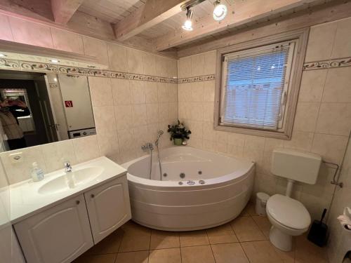 a bathroom with a tub and a sink and a toilet at Ferienhaus Baabe in Baabe