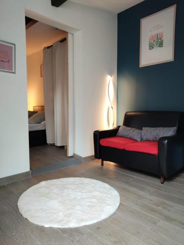a living room with a couch and a red rug at Maisonnette avec Jardin, Piscine, Netflix in Vichy