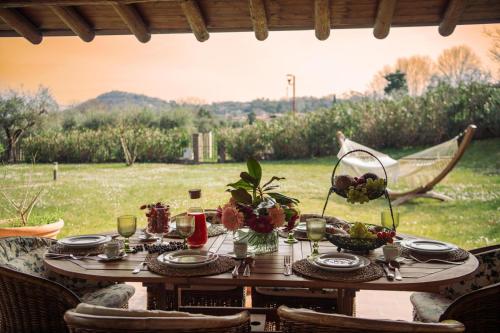 a wooden table with plates and flowers on it at Villa Mary in Montinelle