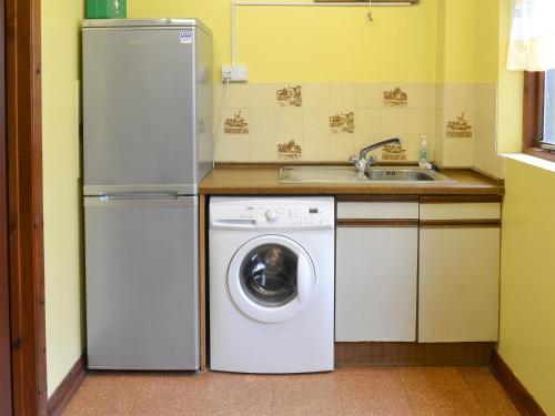 a kitchen with a washing machine and a sink at The Gazebo in Marazion