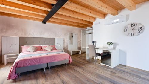 a bedroom with a bed and a desk and a clock at Luxea Guest House - B&B Treviso in Preganziol