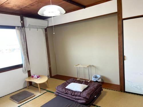a room with a bed in the corner of a room at ゲストハウスまちかど Guest House MACHIKADO in Ibusuki