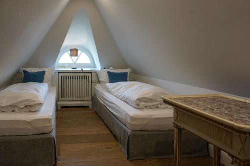 two beds in a attic room with a window at Lachmöwe in List
