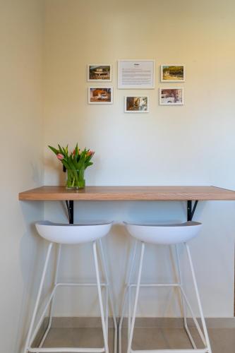 a counter with two stools and a table with a plant at Naus Limen in Marathi