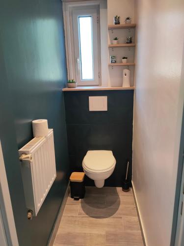 a bathroom with a white toilet and a window at TyCoCoon in Lannion