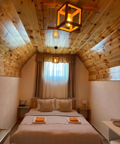 a bedroom with a large bed with a wooden ceiling at Apartment & Rooms Sweet Dreams in Žabljak