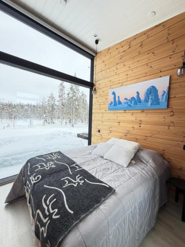 a bedroom with a bed and a large window at Modern Villa JoenPolku Ruka With jacuzzi, sauna and scenic views in Ruka