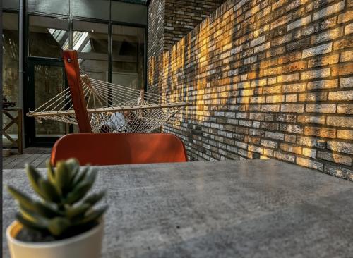 a table and a chair and a hammock on a patio at Suite w kitchen acces,Den bosch- Oss, near train in Oss