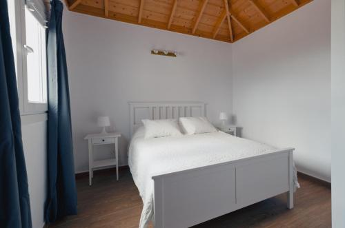a white bedroom with a white bed and a window at VV Casa Los Brezos "by AFCVacacional" in Breña Alta