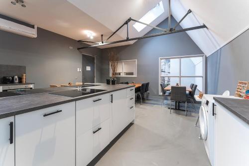 a kitchen with white cabinets and a dining room at Suite w kitchen acces,Den bosch- Oss, near train in Oss