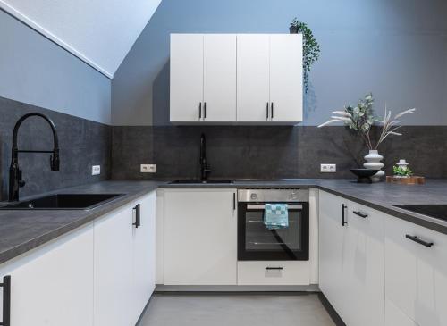 a kitchen with white cabinets and a sink at Suite w kitchen acces,Den bosch- Oss, near train in Oss