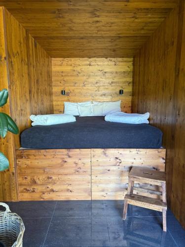 a bed in a log cabin with a wooden wall at Za kovárnou in Zděchov